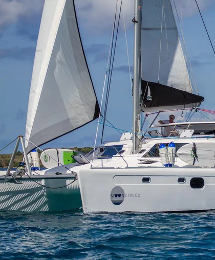 Moonstruck under sail, seen close from off her bow, with her name on the hull
